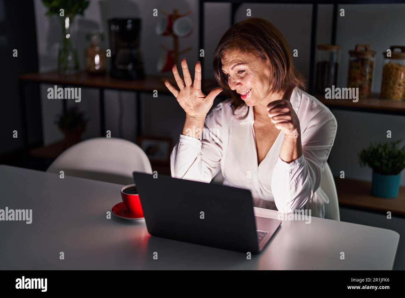 Middle age hispanic woman using laptop at home at night showing and ...