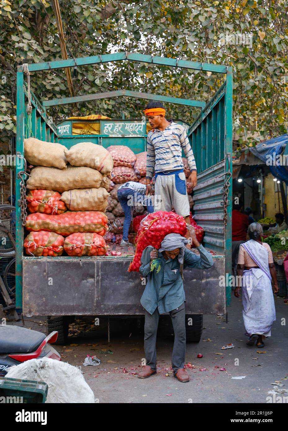 Man unloading sack of onions from a truck at the Paharganj vegetable market , Delhi,India Stock Photo