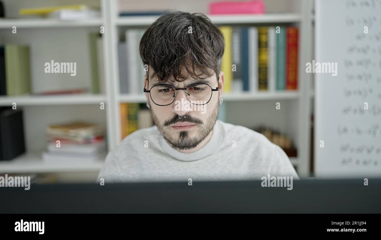 Young hispanic man university teacher using computer at university ...