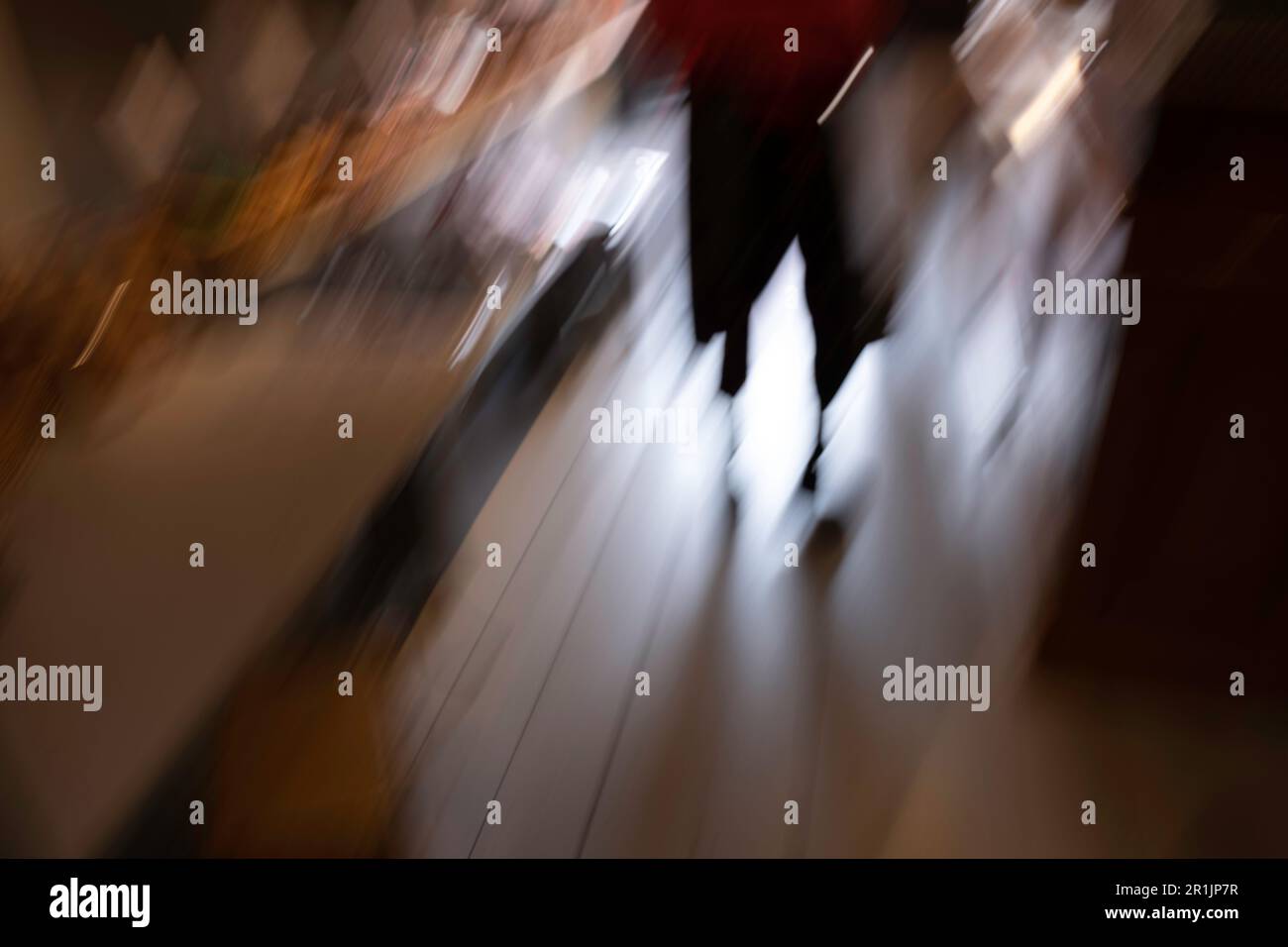 Abstract view with motion blur of a silhouette of a confused person on a wooden floor with backlight. Background image Stock Photo