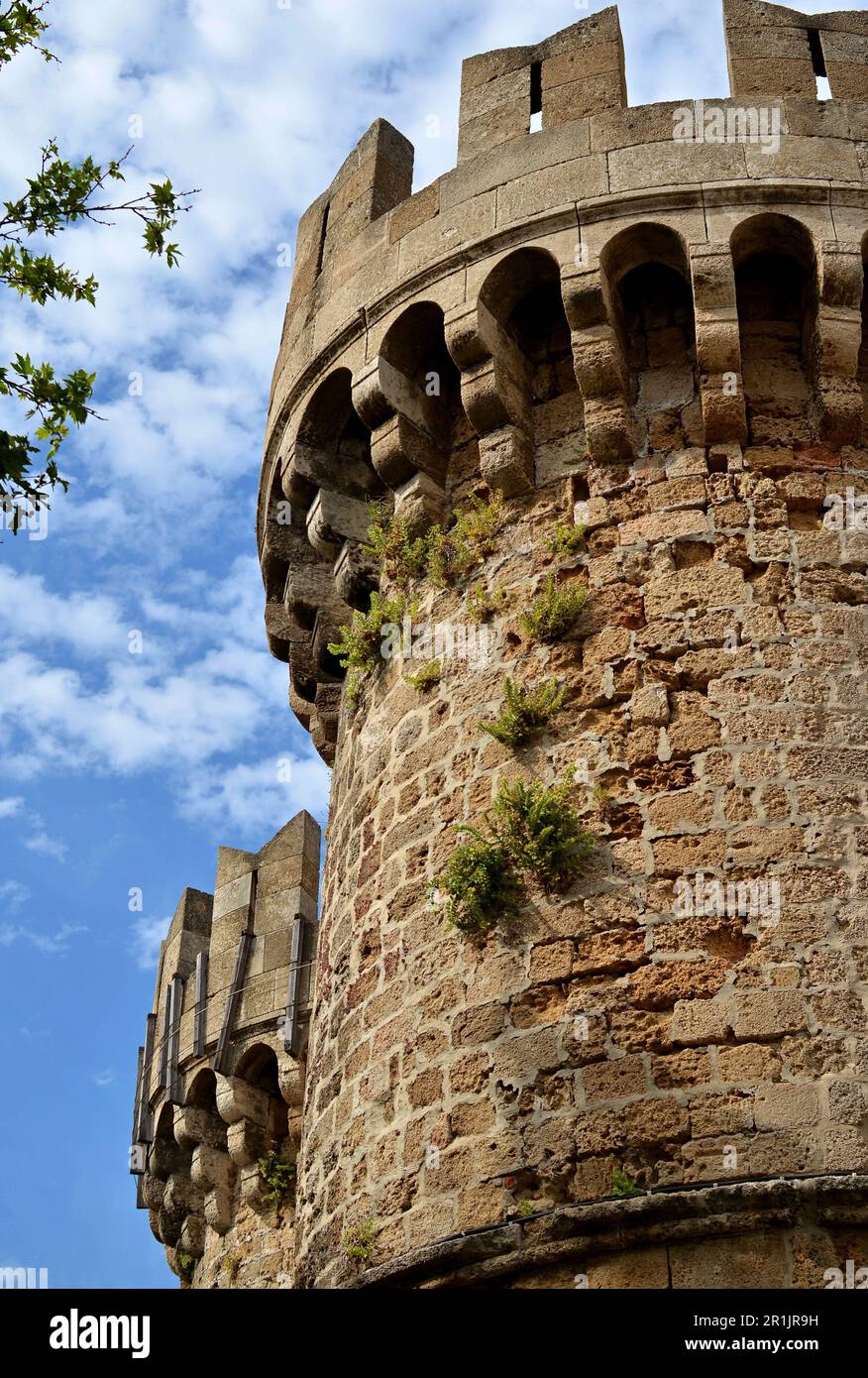 Semicircular medieval towers with battlements made of sandstone stone in the old town of Rhodes. Defensive towers of the knightly order Stock Photo