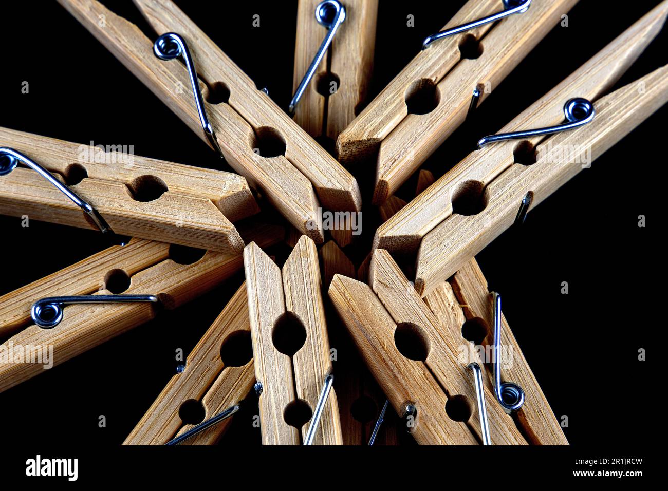 Closeup view of a pile of wooden clothes pegs on a black surface Stock Photo