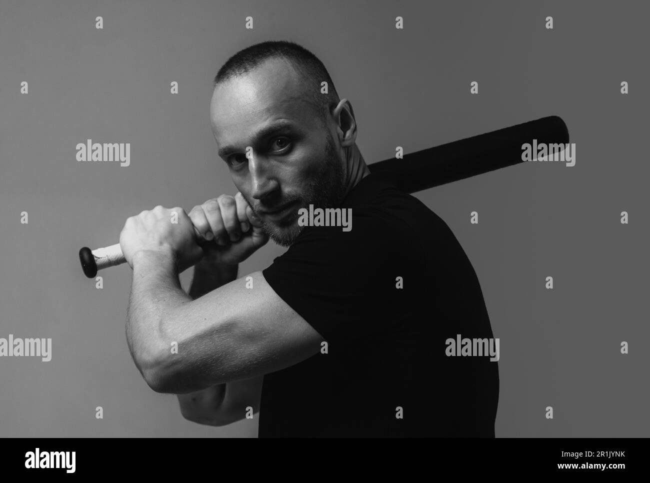 Brutal man, handsome serious male model. Guy with baseball bat for