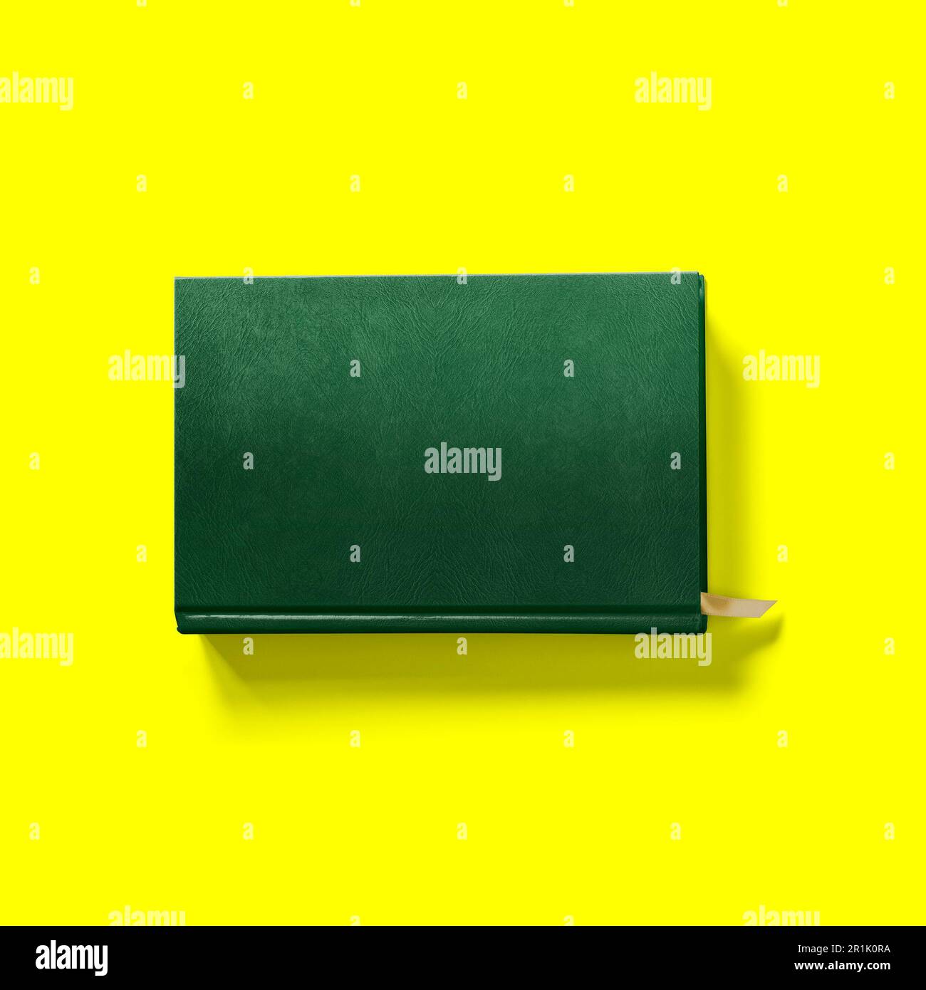 Back to school concept , hard cover dark green book front close isolated on yellow. Stock Photo