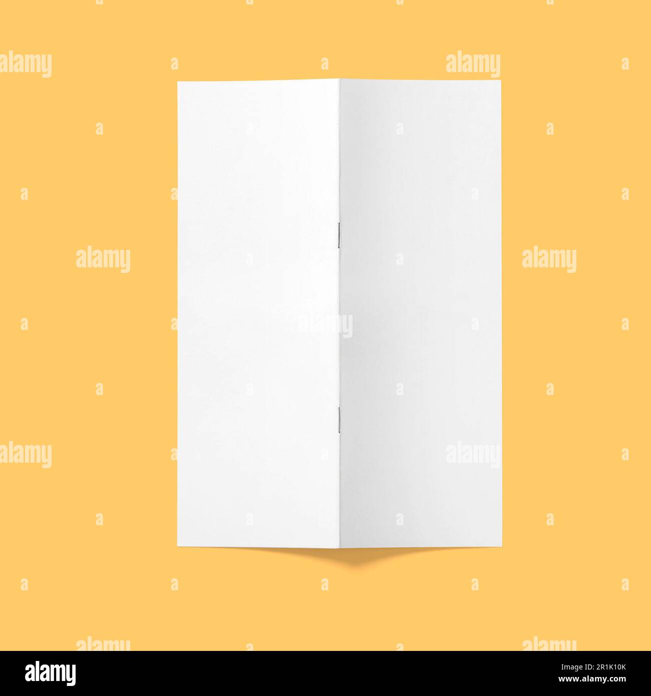 Top up view blank white brochure vertical upside down open isolated on bright brown background