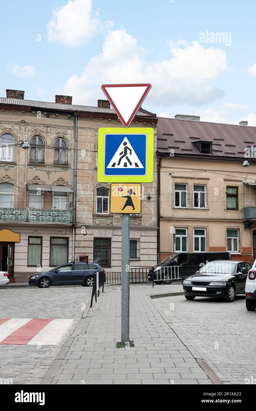 Post with different road signs on city street Stock Photo - Alamy