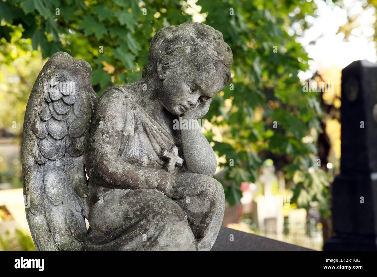 Beautiful statue of angel at cemetery on sunny day, space for text