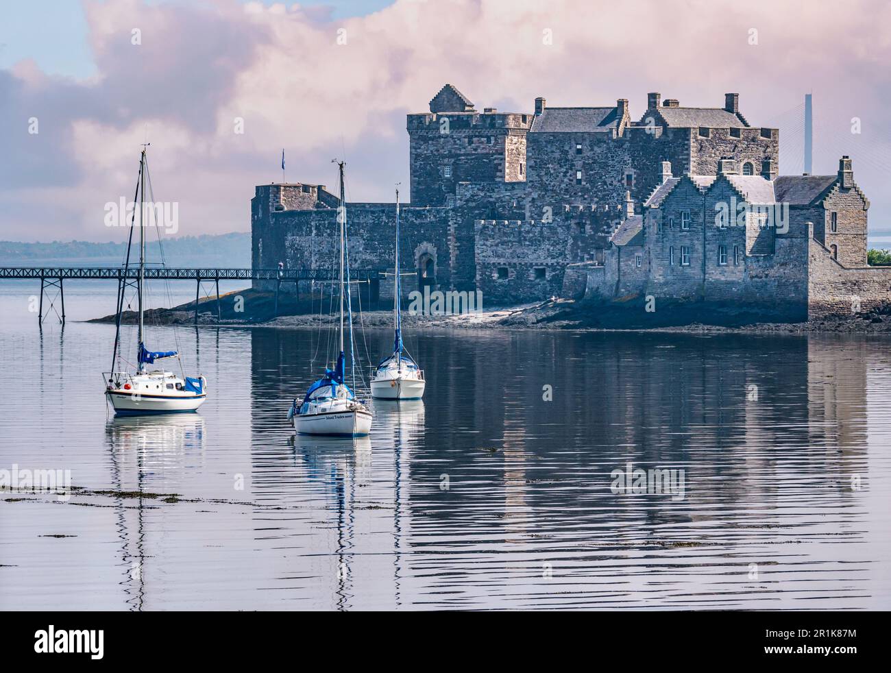 Blackness Castle on hazy sunshine with moored sailboats in calm water, Firth of Forth, Scotland, UK Stock Photo