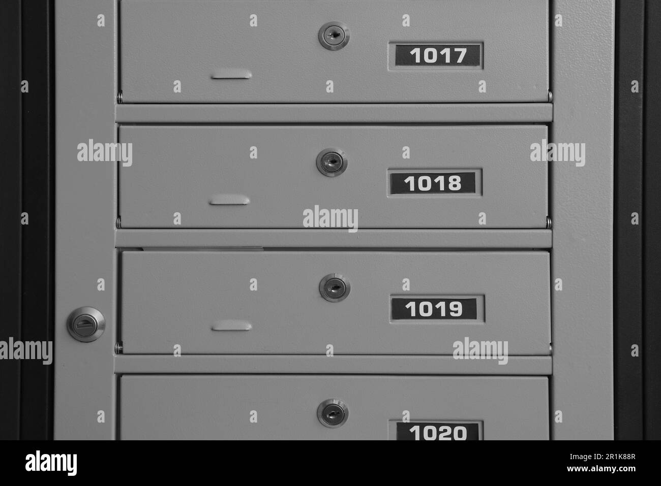 Closed metal mailboxes with keyholes and sequence numbers indoors Stock