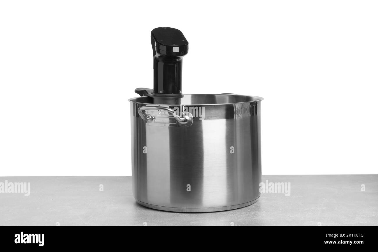 Sous vide cooker in pot on light table against white background. Thermal immersion circulator Stock Photo