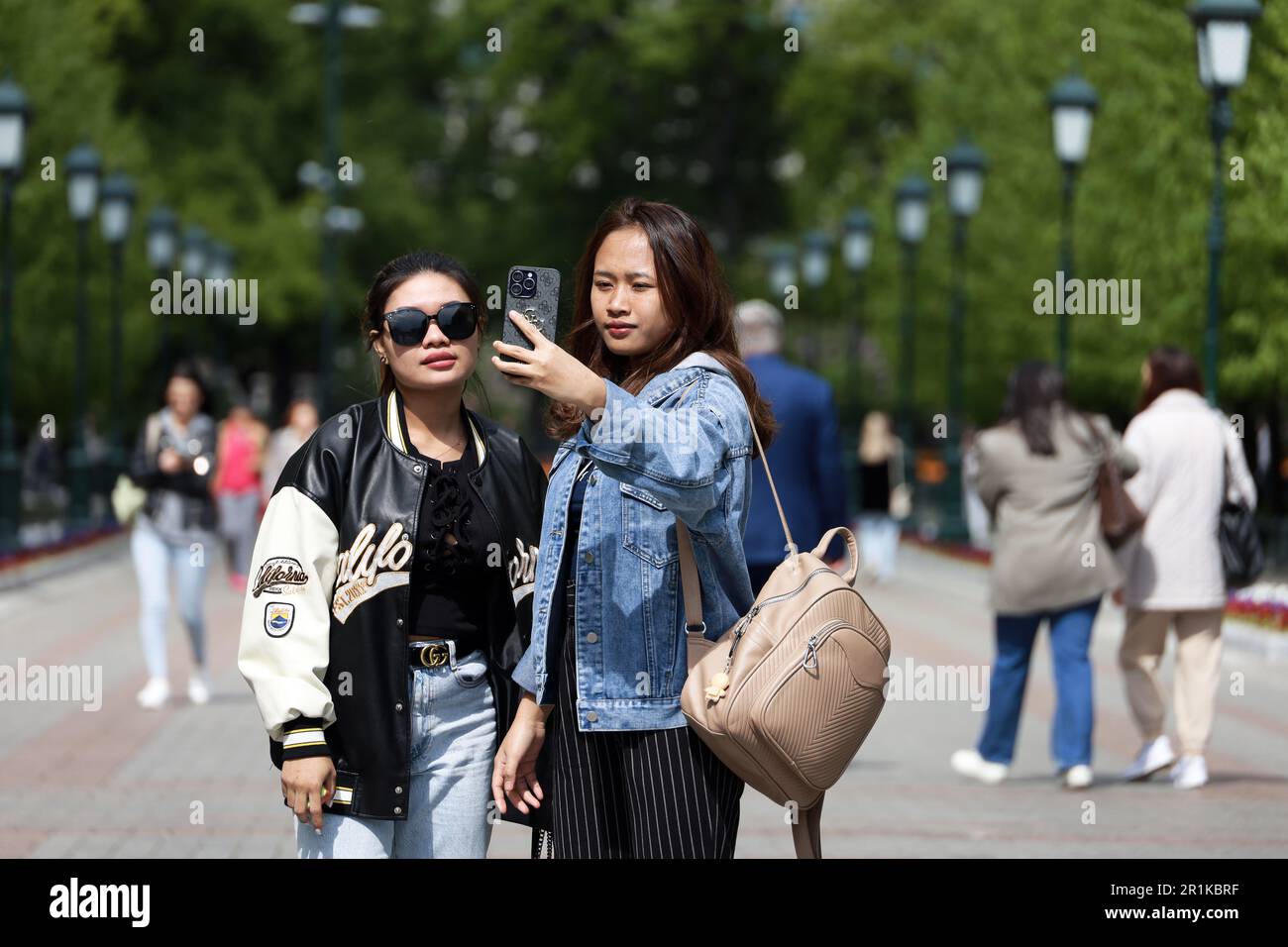 Asian girls tourists taking selfie on smartphone camera in the Alexander garden Stock Photo