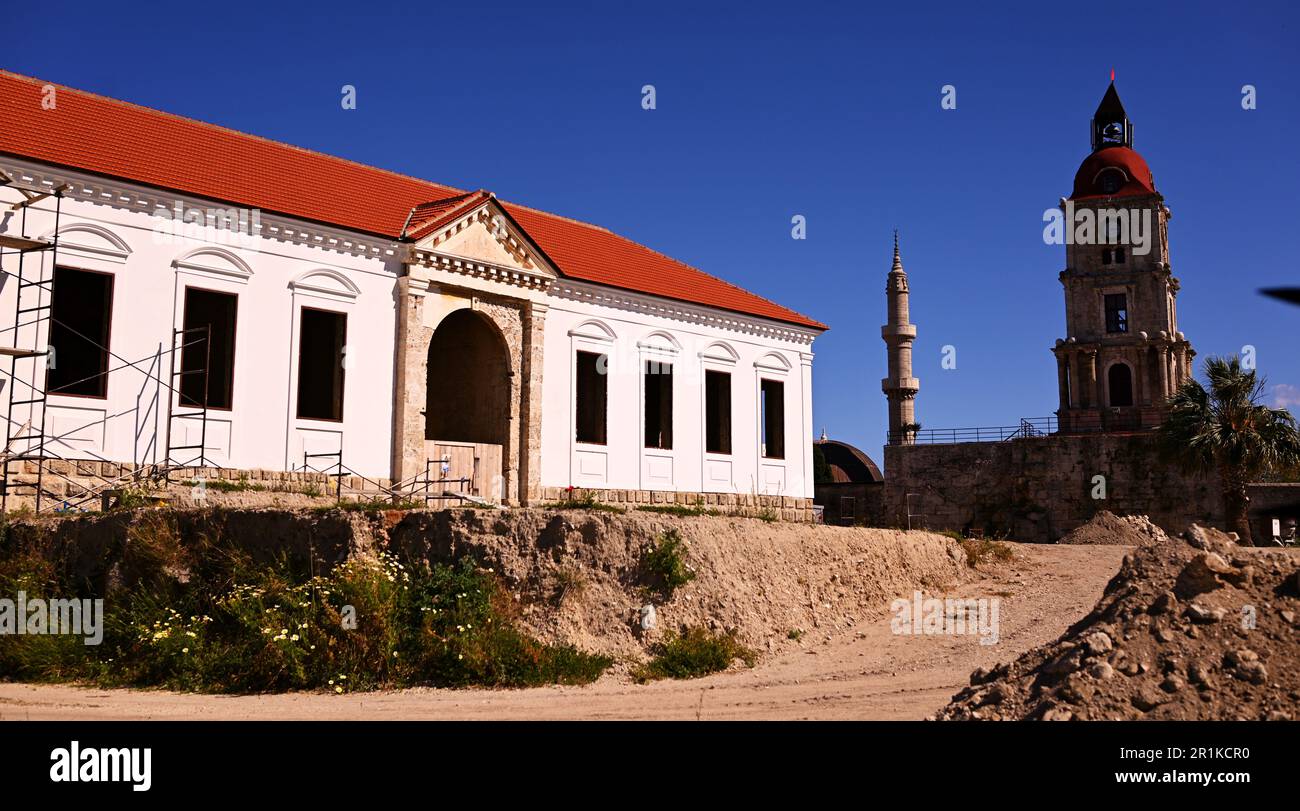A medieval fire tower with a clock and a reconstructed neoclassical building with a ceramic roof.The buildings are located on the medieval old town. Stock Photo