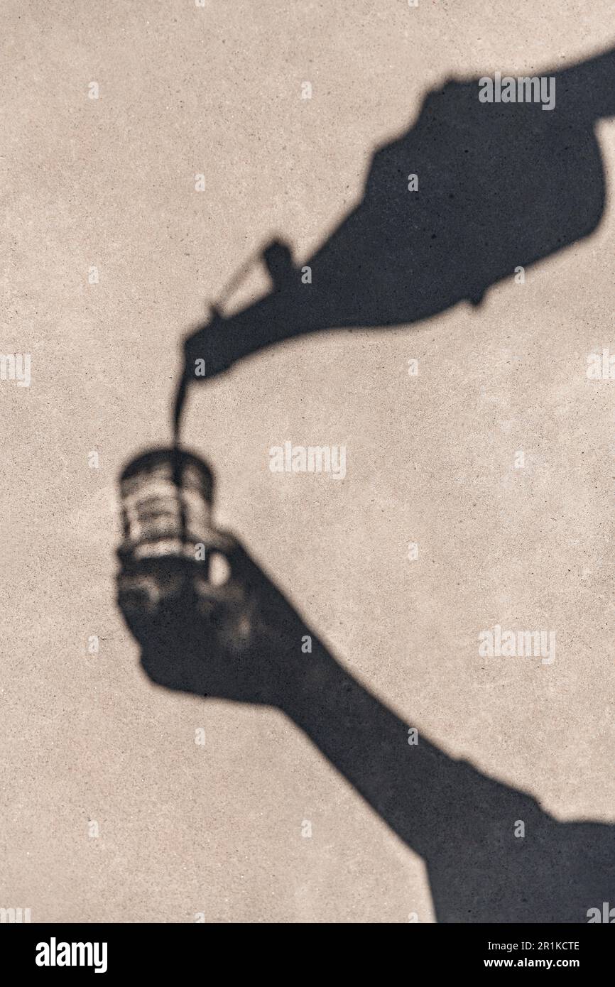 shadow of hands pouring drink from bottle to glass Stock Photo - Alamy