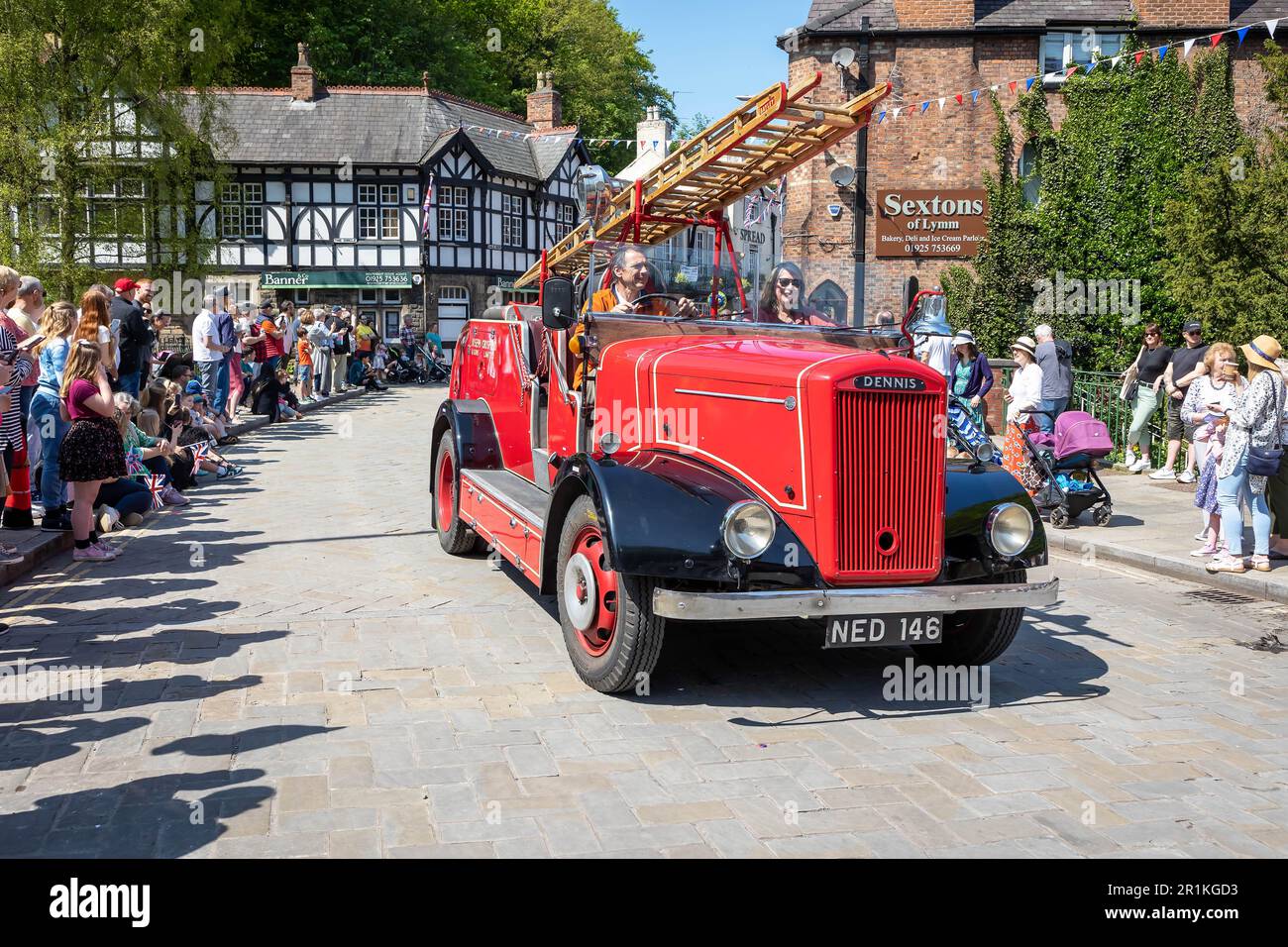 Lymm May Queen and Rose Queen 2023. Joseph Crosfield (Dennis) fire engine passes through the village Stock Photo