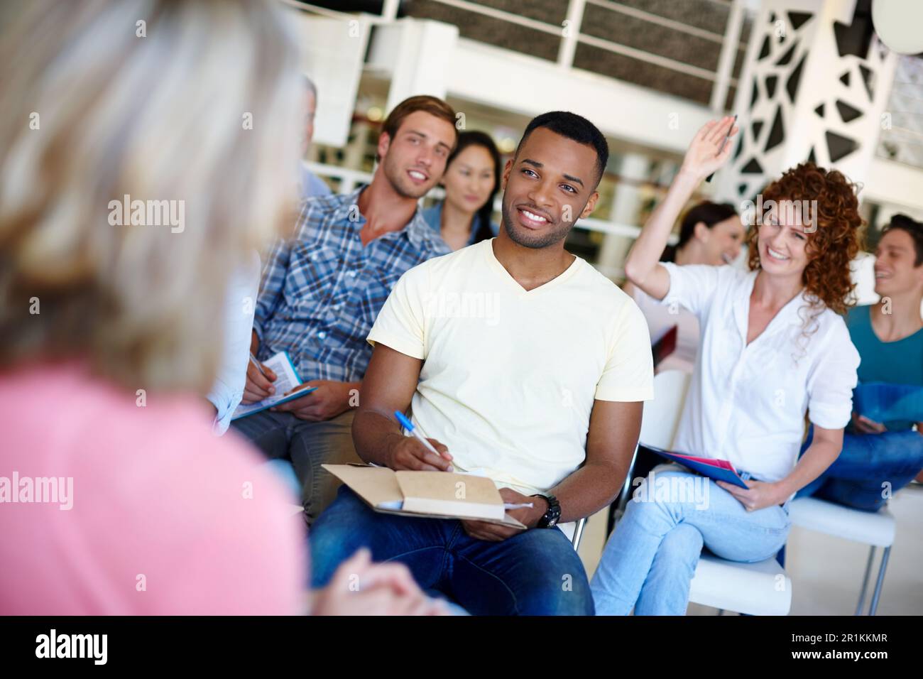 taking notes to remember it all. woman asking a question during a presentation at work. Stock Photo