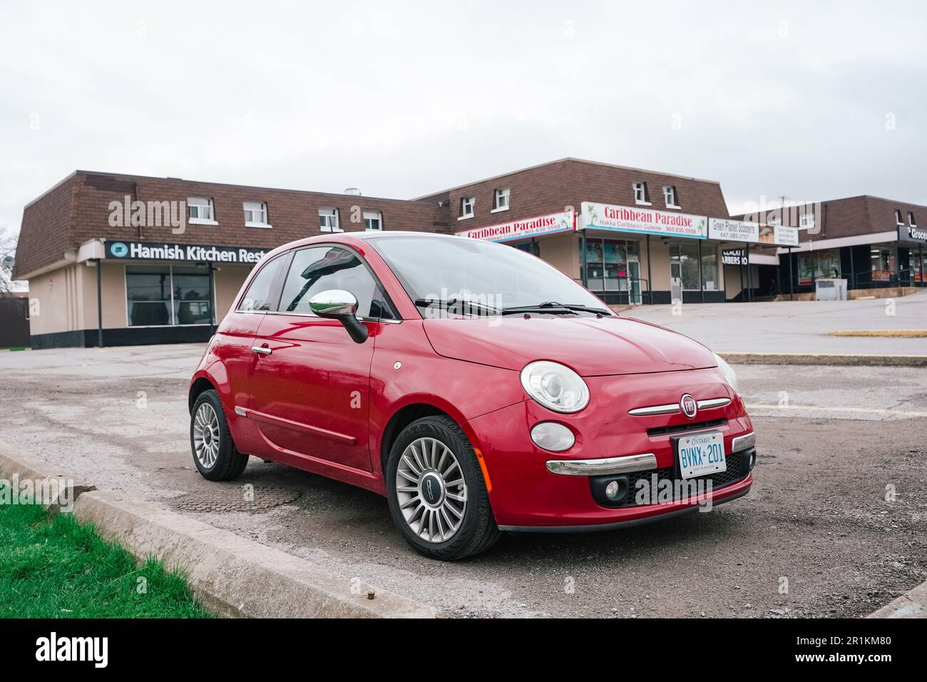 Red fiat 500 car parked in a parking lot of a strip mall in Canada ...