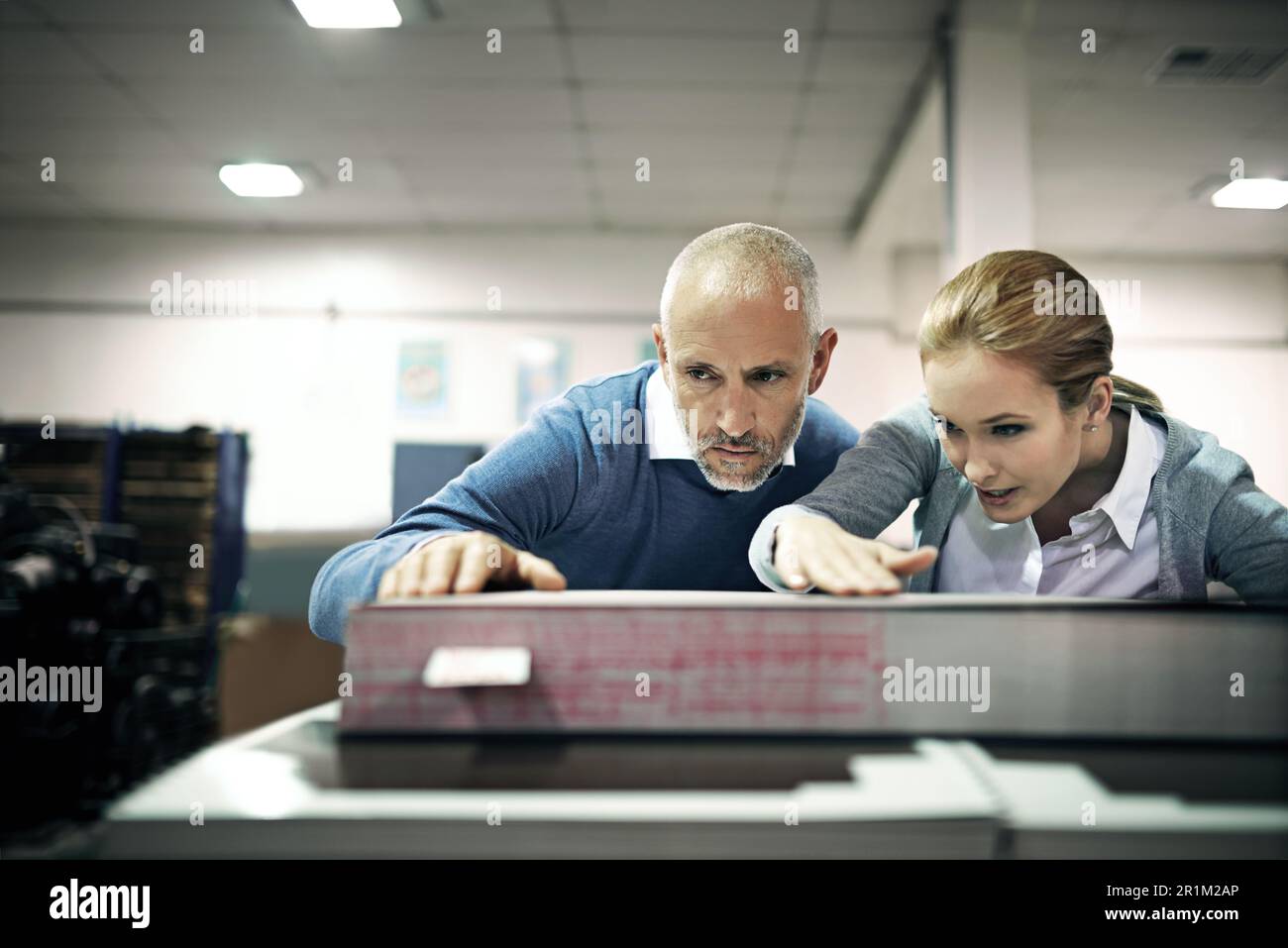 This is some good work. two managers looking over samples while standing inside a printing and packaging plant. Stock Photo