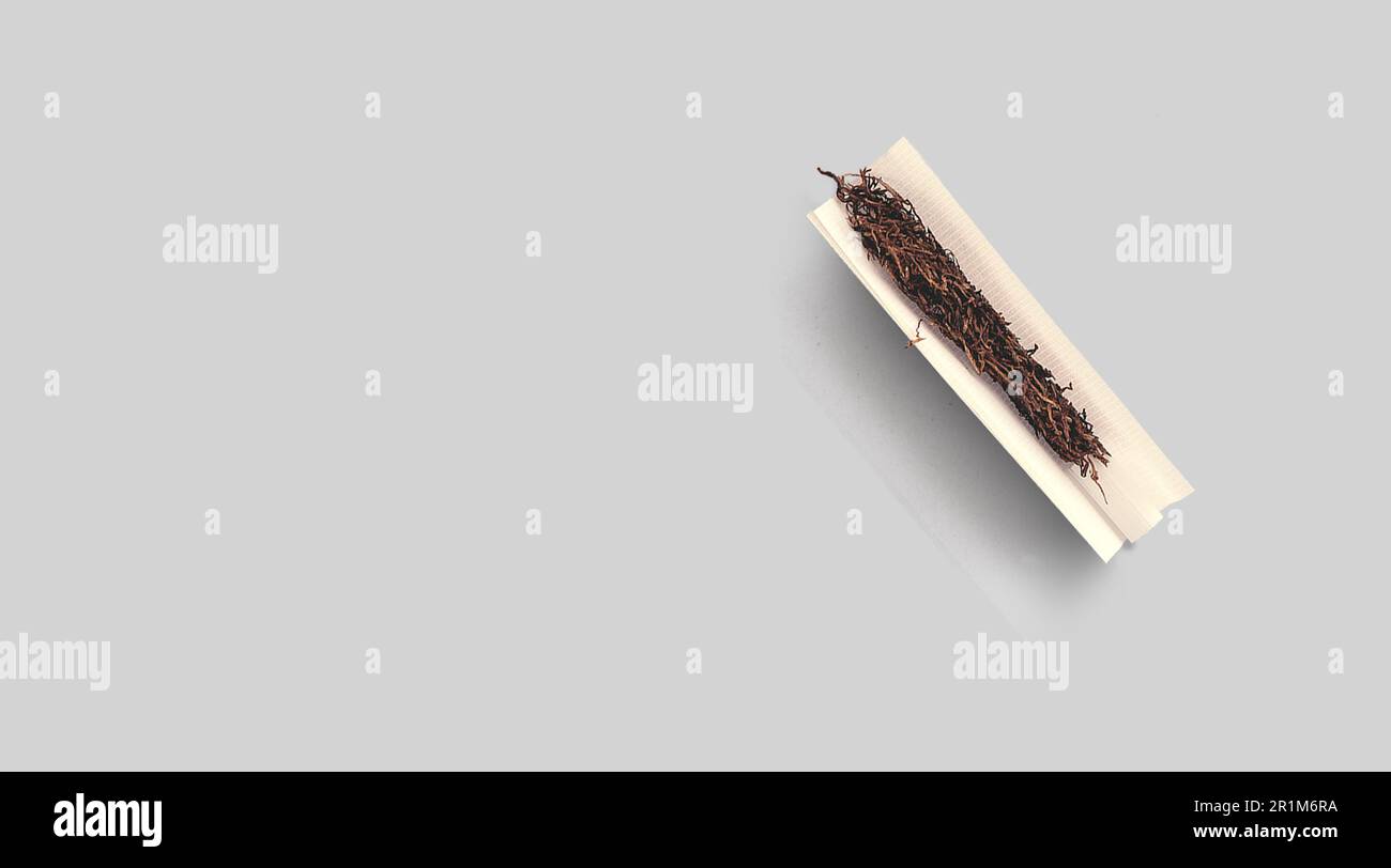 Handmade cigarette with pre-cut cigarette filter and tobacco paper. Close-up, top view Stock Photo