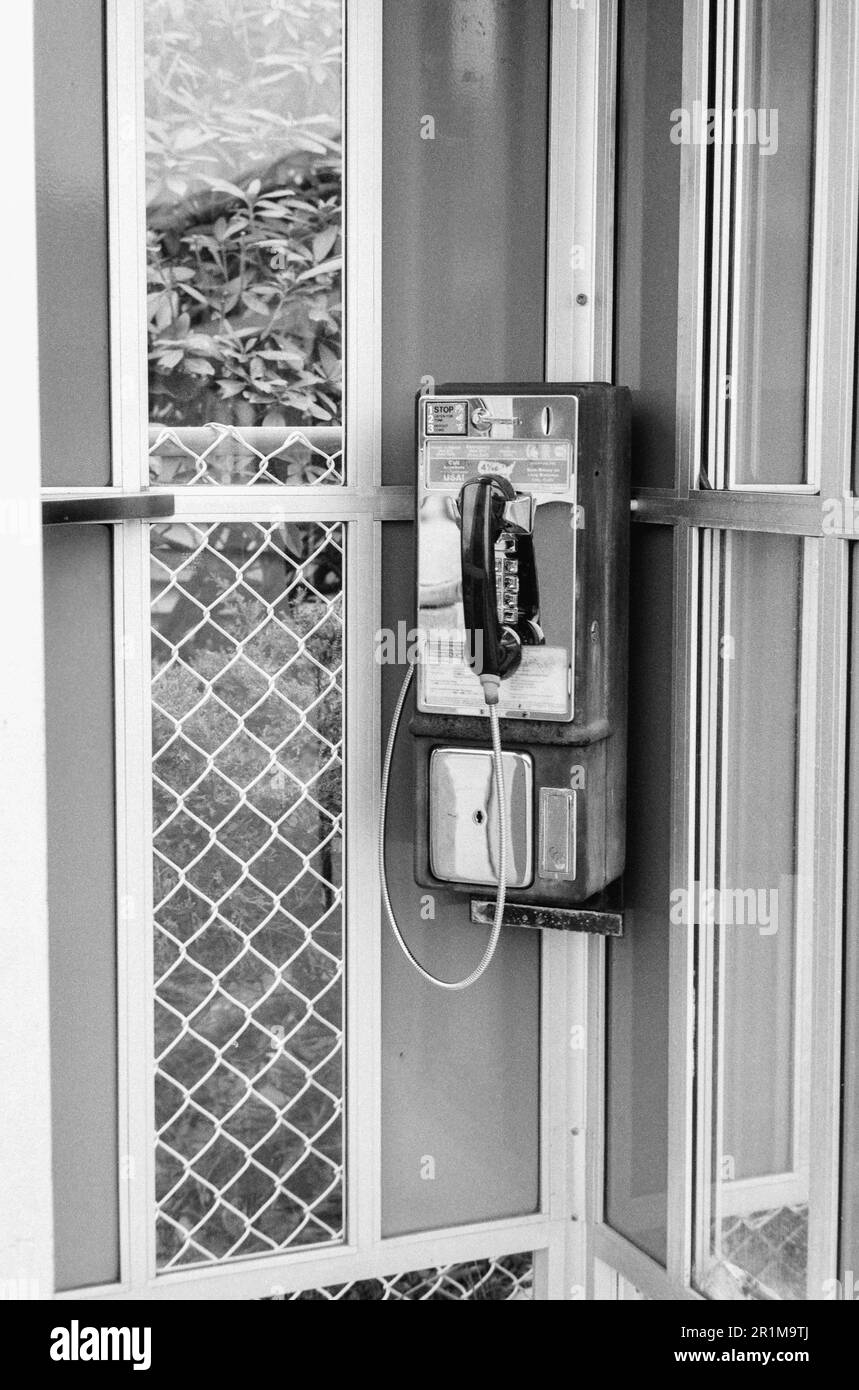 A vintage working payphone hangs in a phonebooth at a public highway ...