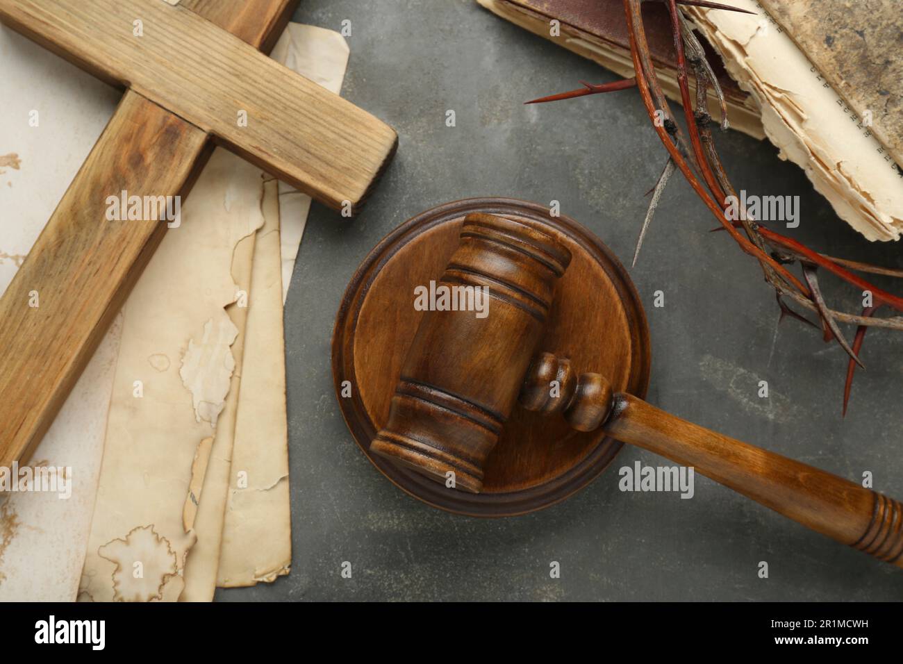 Judge gavel, wooden cross and crown of thorns on grey table, flat lay