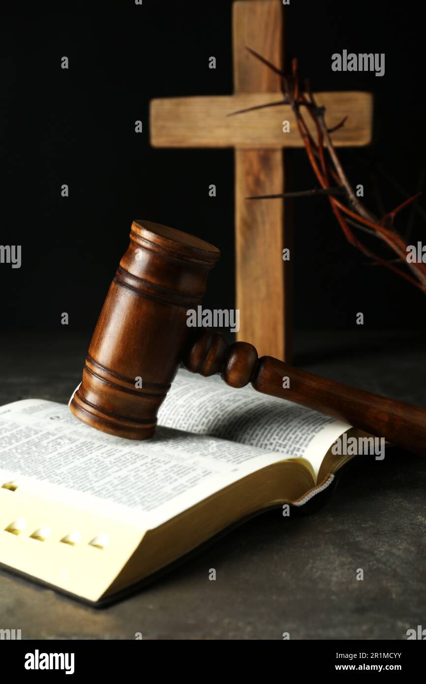 Judge gavel, bible, wooden cross and crown of thorns on grey table