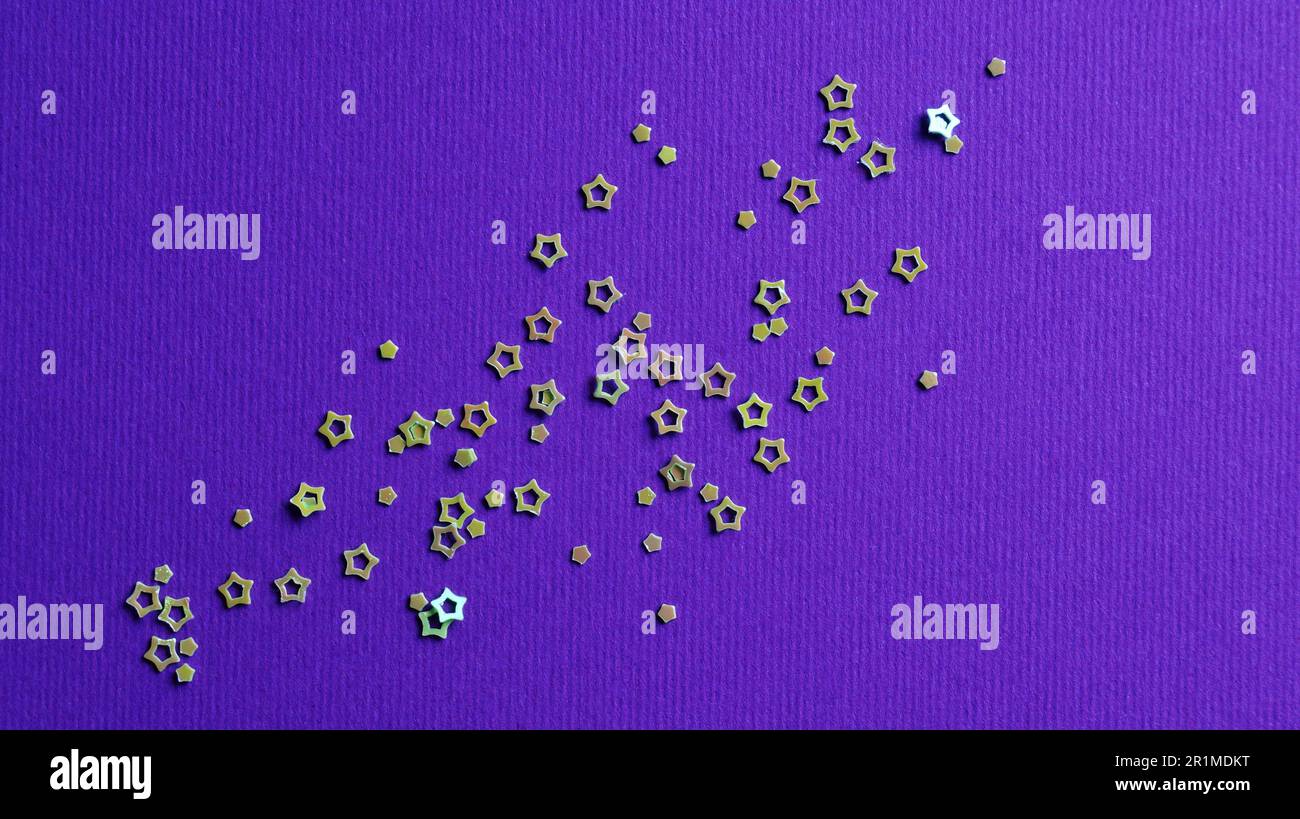 Many silver star shaped sequins on purple background, flat lay Stock Photo