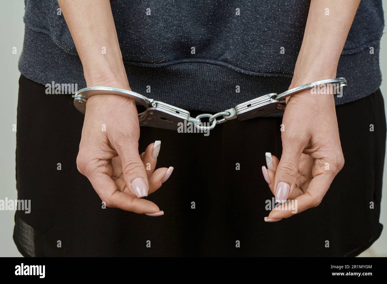women's hands are handcuffed in close-up Stock Photo