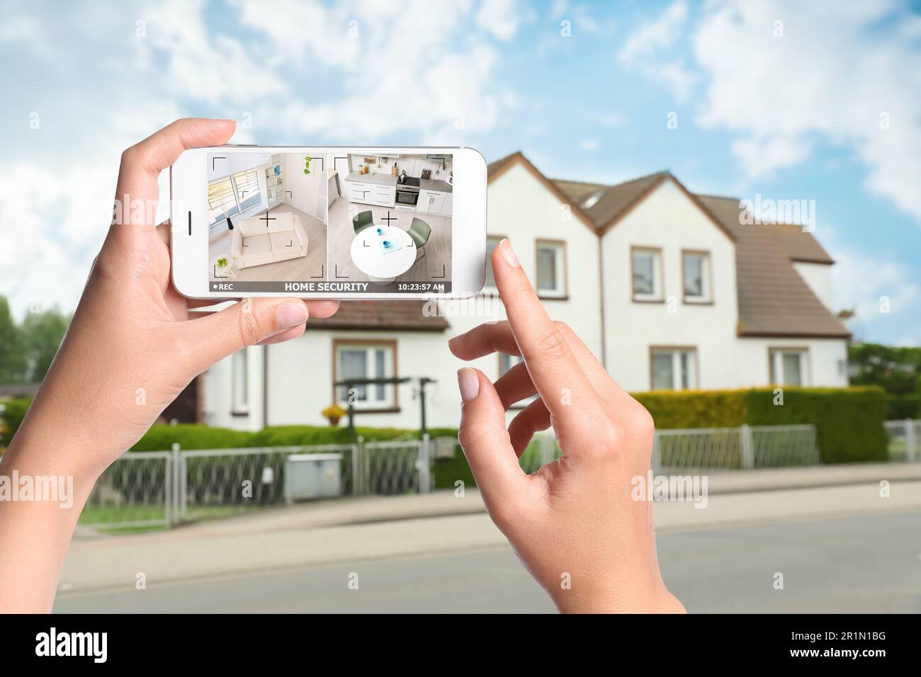 Home security system. Woman monitoring CCTV cameras on smartphone near ...