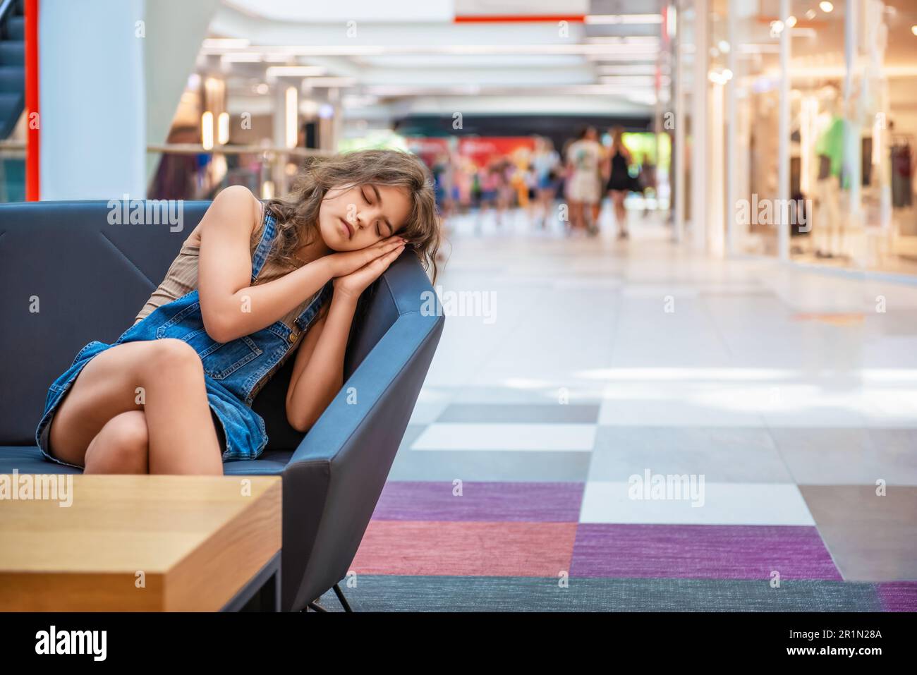 Tired teenage girl sleeping on sofa in shopping mall Stock Photo Alamy