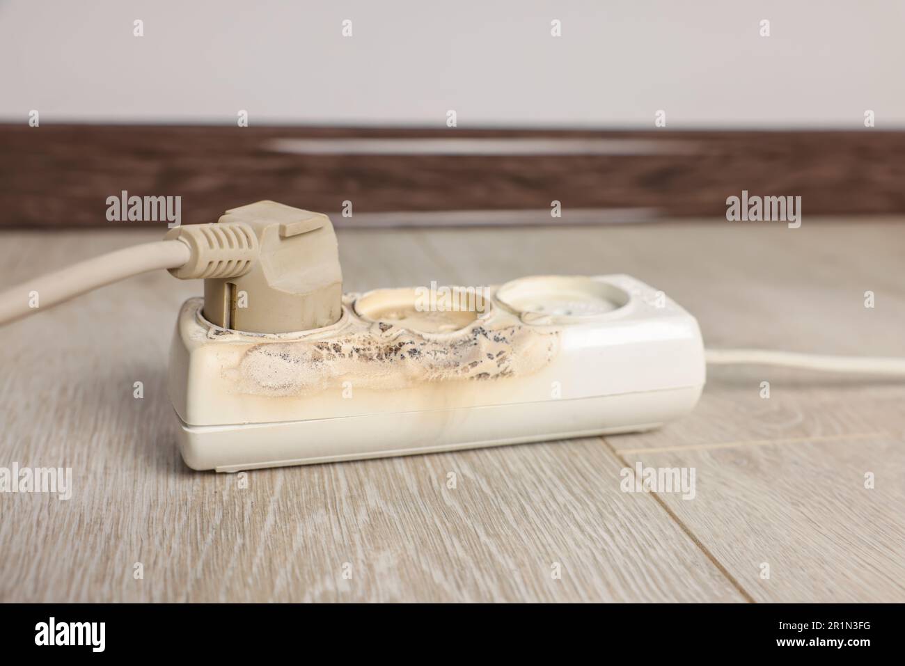 Burnt power strip indoors, closeup. Electrical short circuit Stock