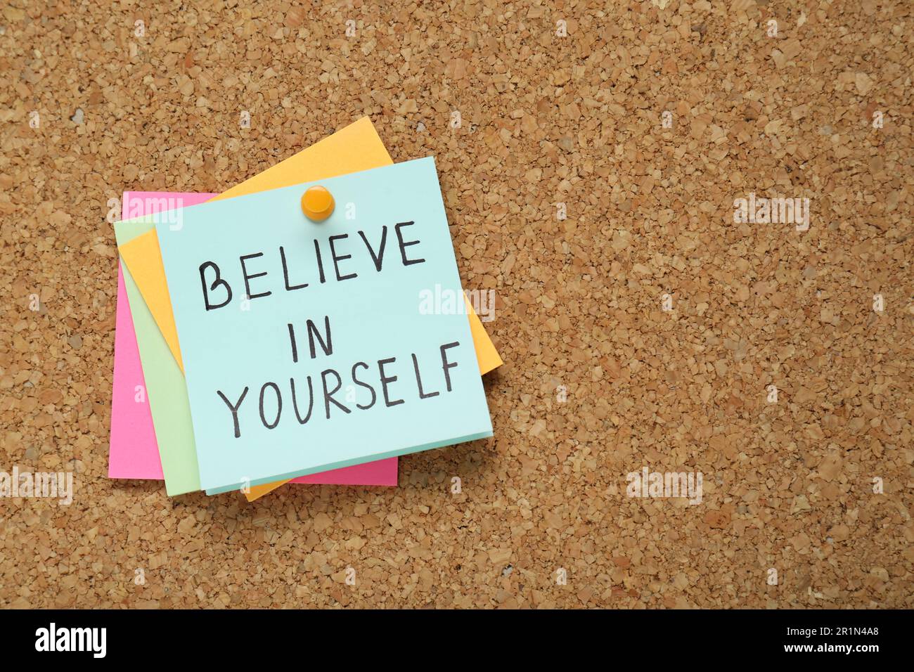 Notes with phrase Believe In Yourself and space for text on corkboard ...