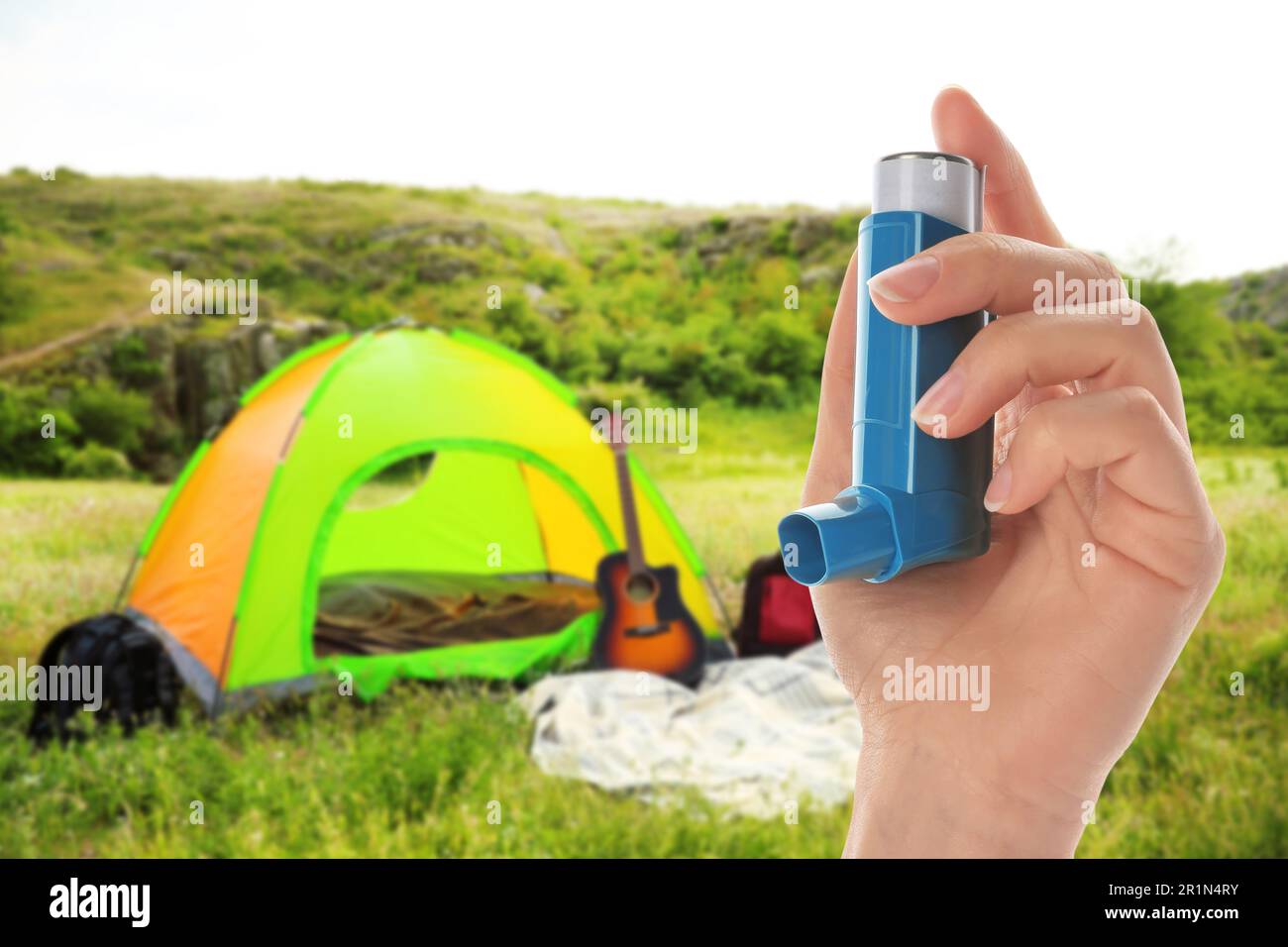 Young woman using asthma inhaler outside on sunny day, closeup ...