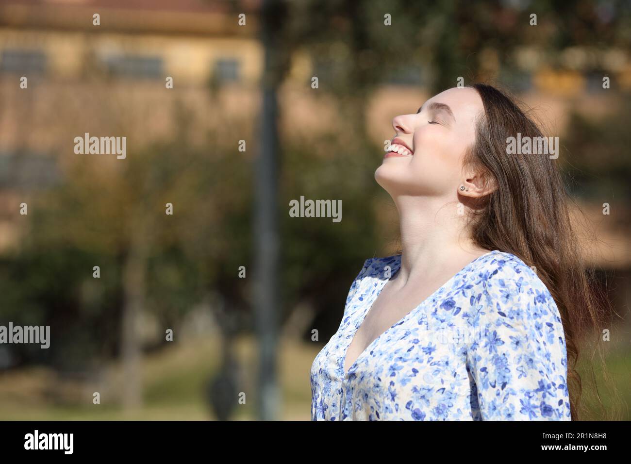 Side view portrait of a happy woman breathing fresh air in a park Stock Photo
