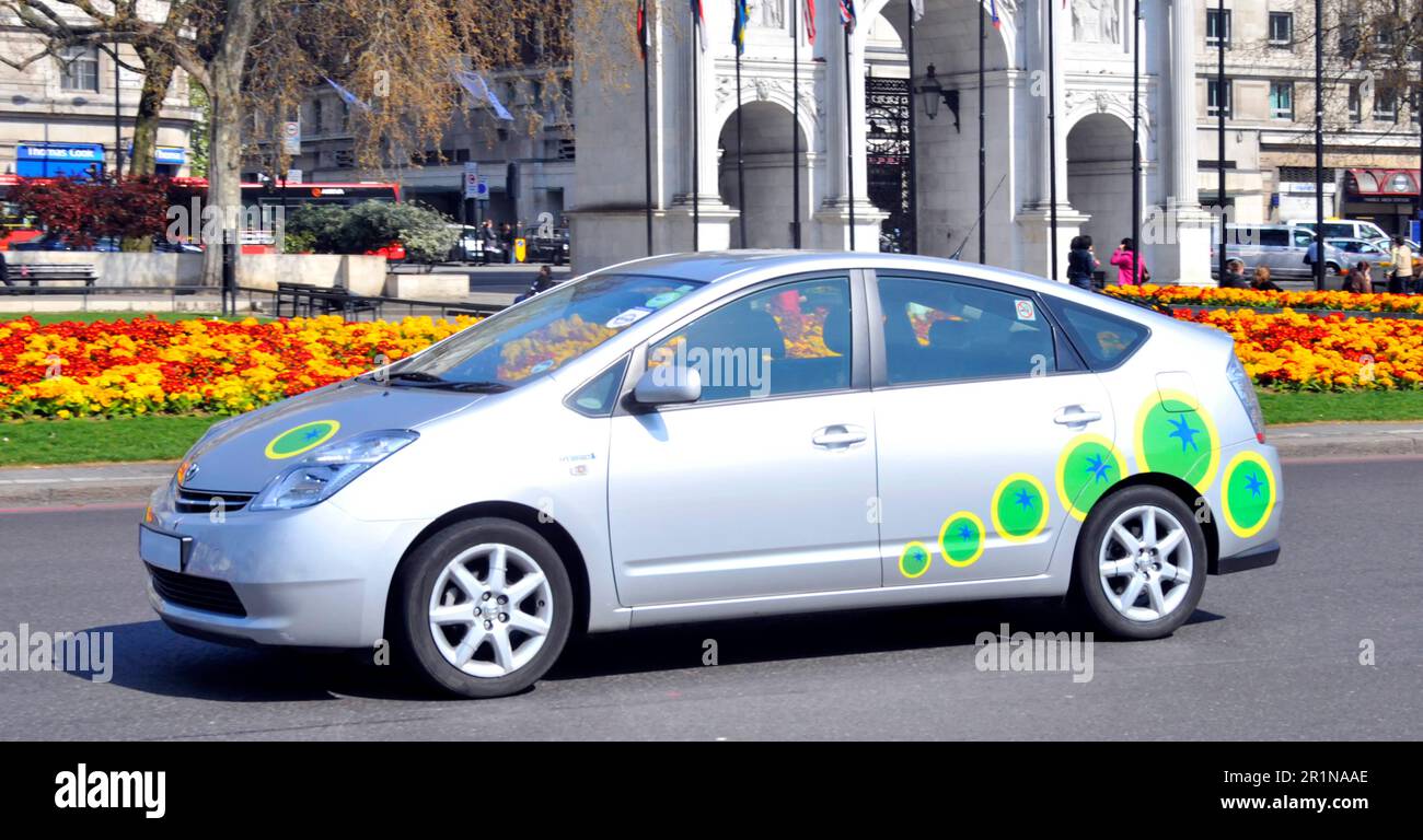 Toyota Prius a Hybrid car combining internal combustion engine with electric motor a five-door liftback passing Marble Arch in 2010 London England UK Stock Photo