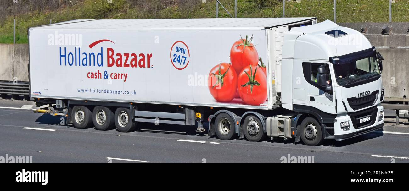 White Iveco hgv lorry truck Holland Bazaar wholesale cash  & carry business Schmitz trailer fitted Ferroplast insulation driving M25 motorway road UK Stock Photo