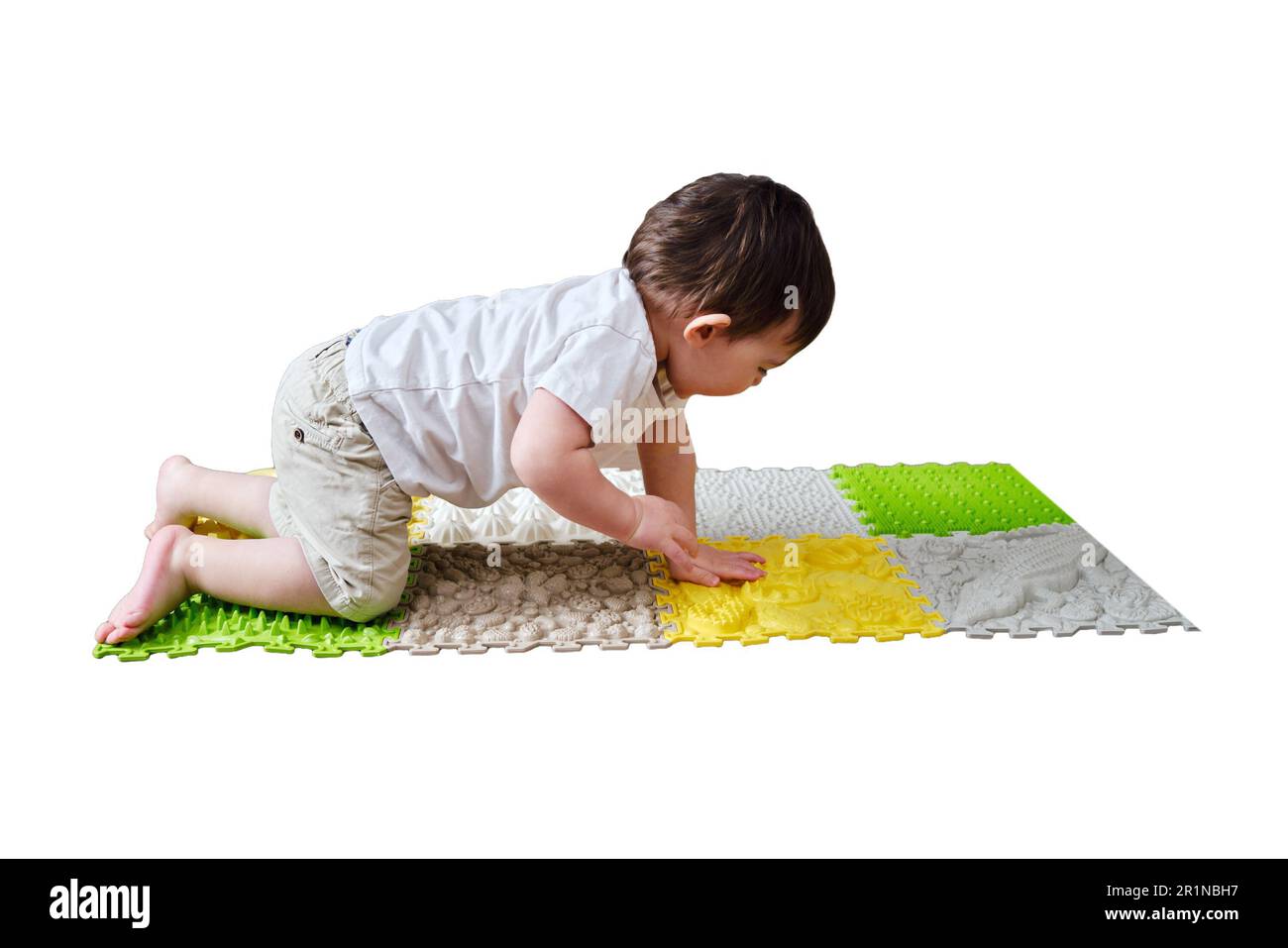 Baby toddler foots close-up on a medical orthopedic mat, isolated on white background. Child legs with flat feet on a medical rug, isolated on white b Stock Photo