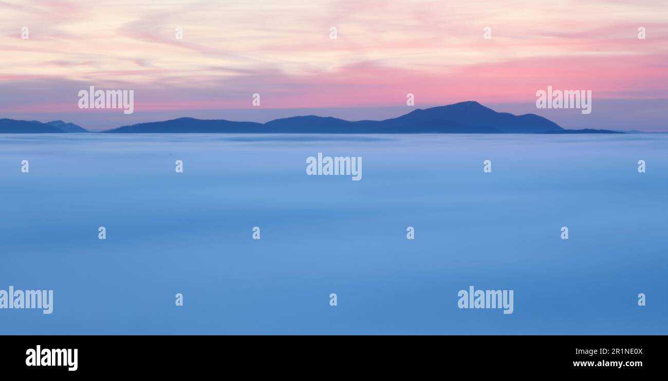 Dramatic clouds with mountain silhouette in dawn, Slovakia. Stock Photo