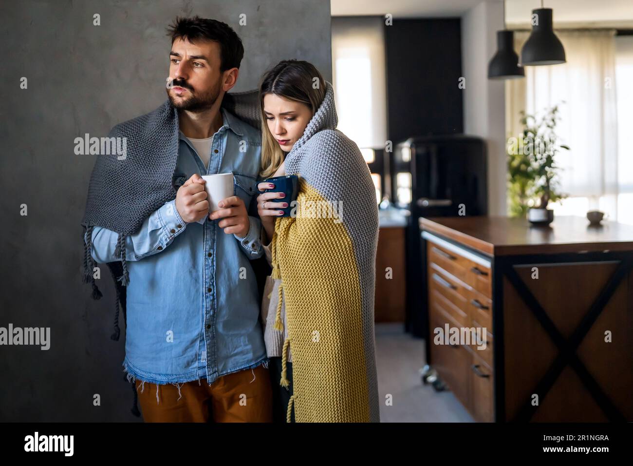 Freezing couple covered with a blanket. Man and a woman wrapped in a