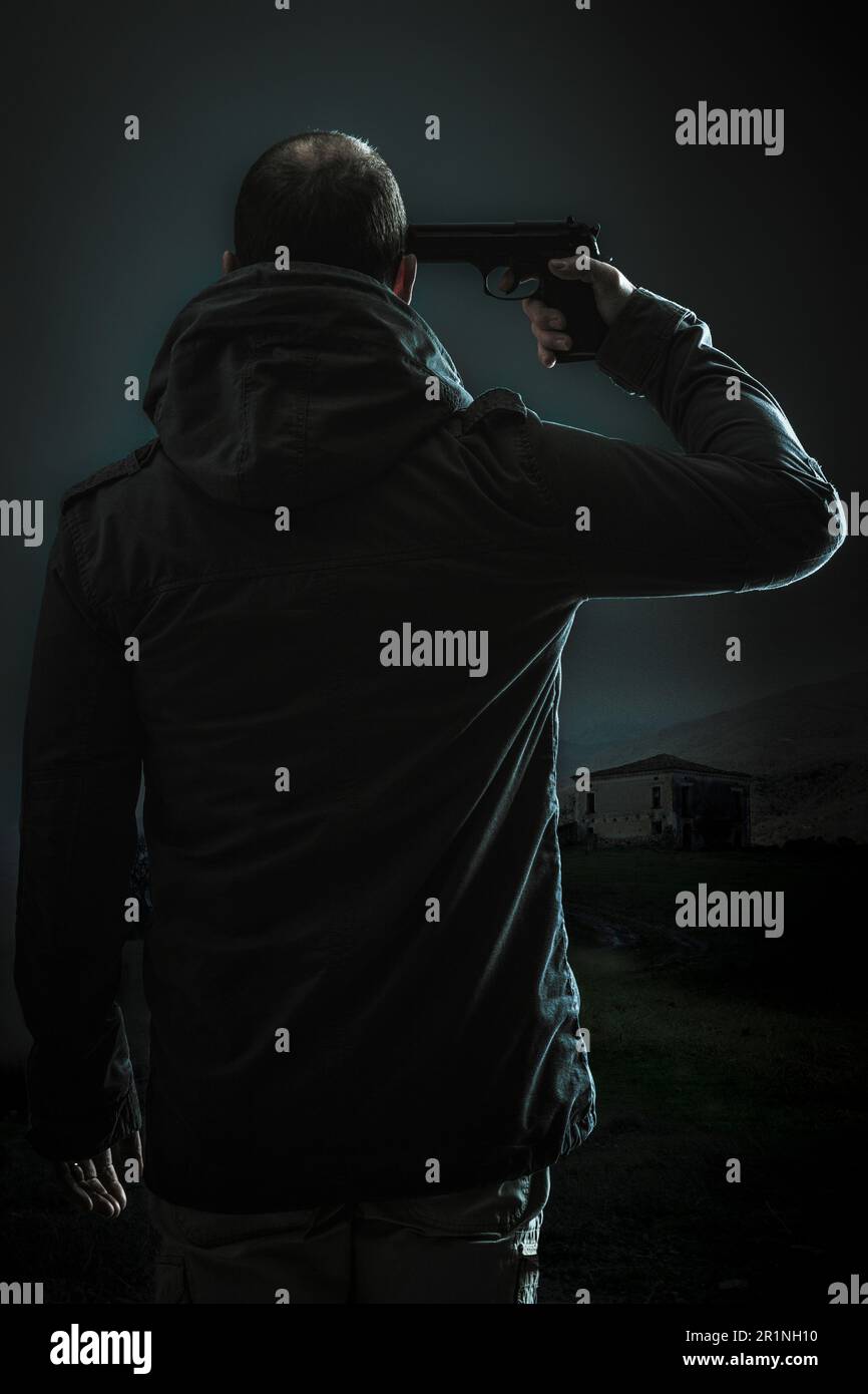 man with gun pointed at head dark background Stock Photo