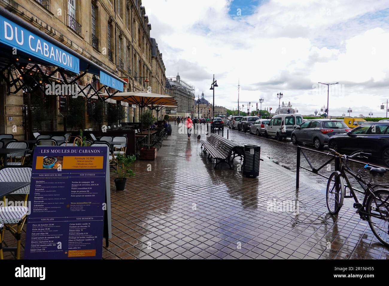 Everyday life, woman walking dog near the river on a rainy day in Bordeaux, France. Stock Photo