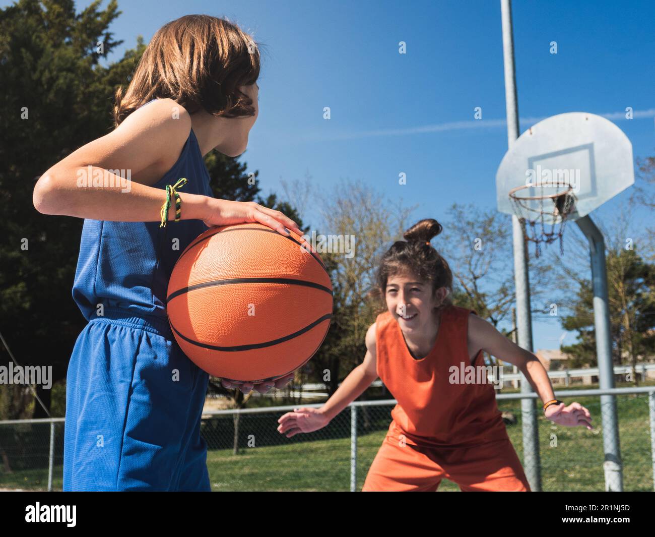 Oneonone basketball between two boys on an outdoor court Stock Photo