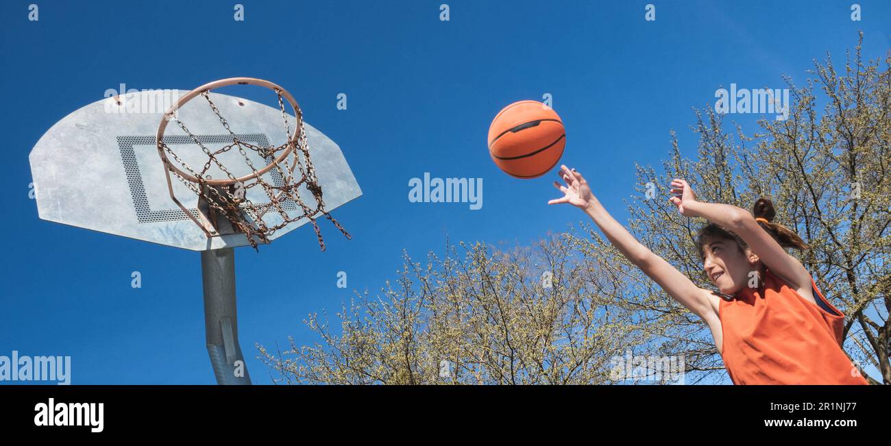 Panoramic photo of a boy shooting a basketball shot on an outdoor Panoramic photo of a boy shooting a basketball shot on an outdoor