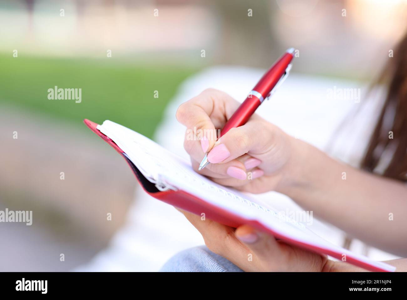 Close up of a hand wrting in paper agenda in the street Stock Photo