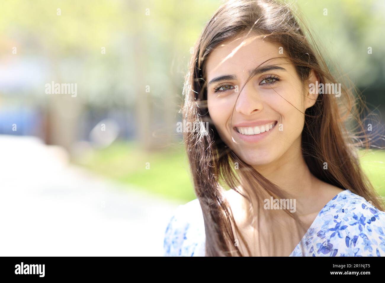Happy woman with tousled hair looks at you in the street Stock Photo