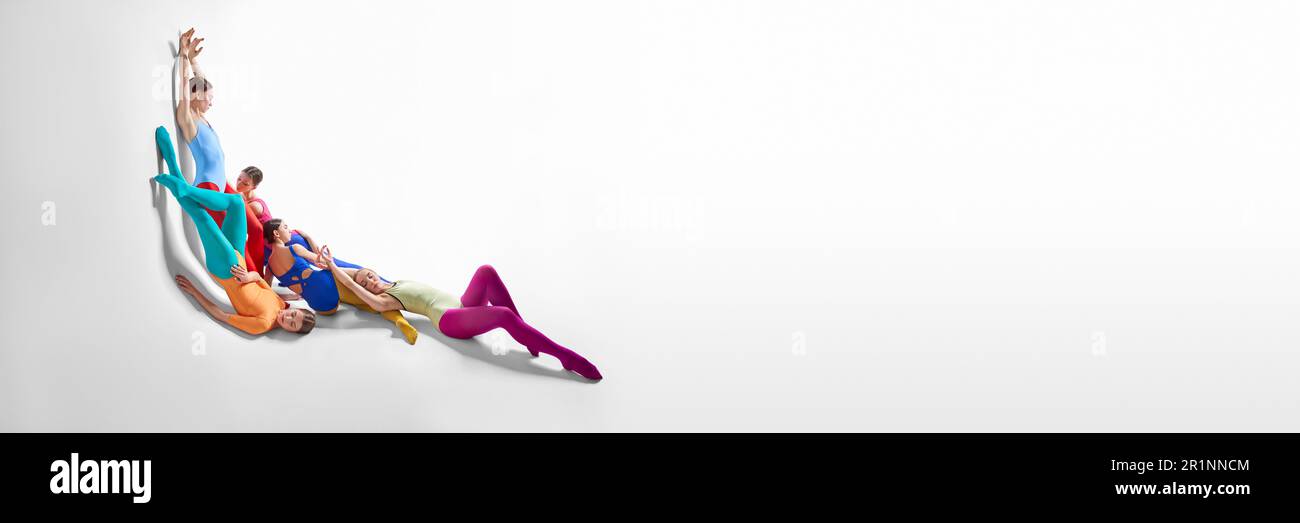 Young girls, ballet dancers performing, dancing against grey studio