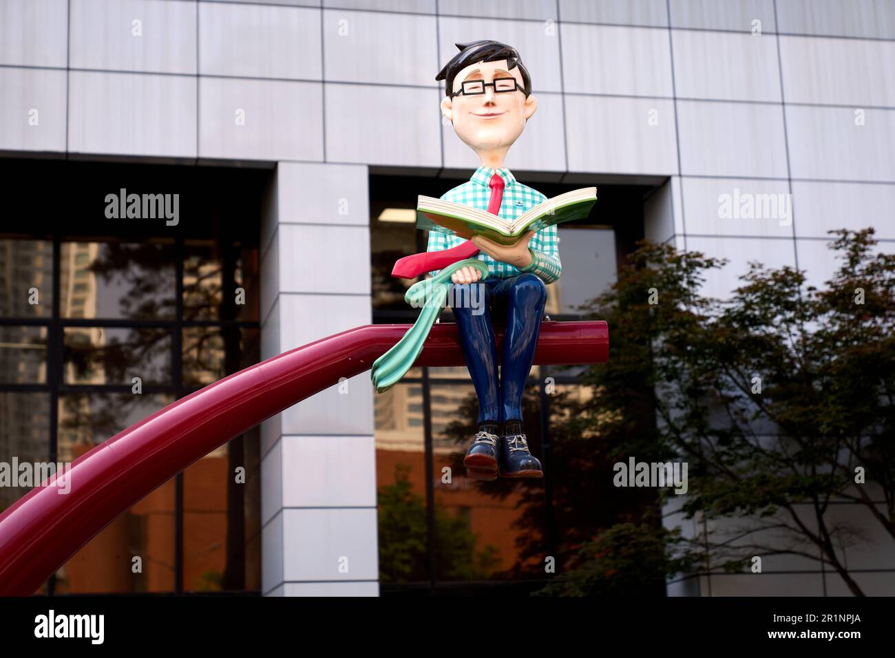 A sculpture of a person sitting reading a book outside of the Songpa-gu Office in Seoul, Republic of Korea Stock Photo