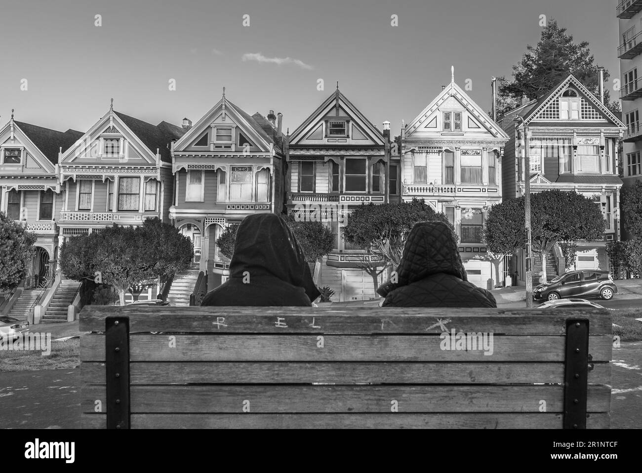 Two people sitting on their backs looking at Painted Ladies. Stock Photo
