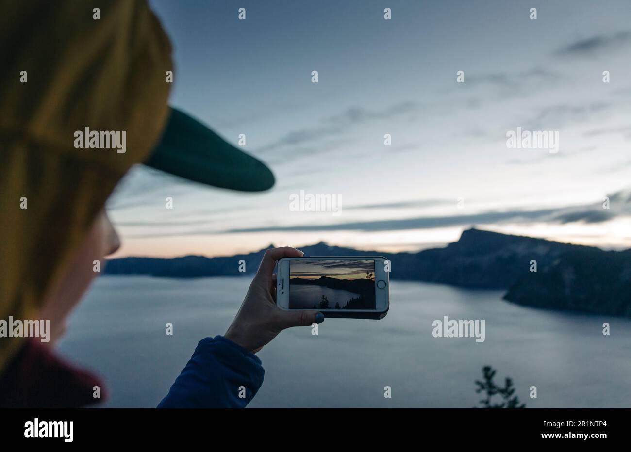 A woman takes a photo of Crater Lake National Park in Oregon. Stock Photo