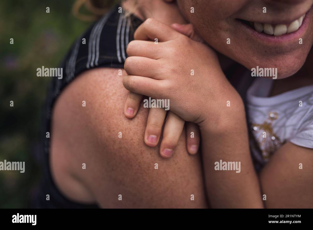 Midsection of happy mother embracing daughter in forest Stock Photo
