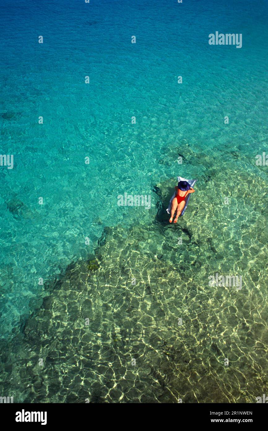 Crystal Clear Caribbean Water with Woman on a Raft in Bonaire Stock Photo